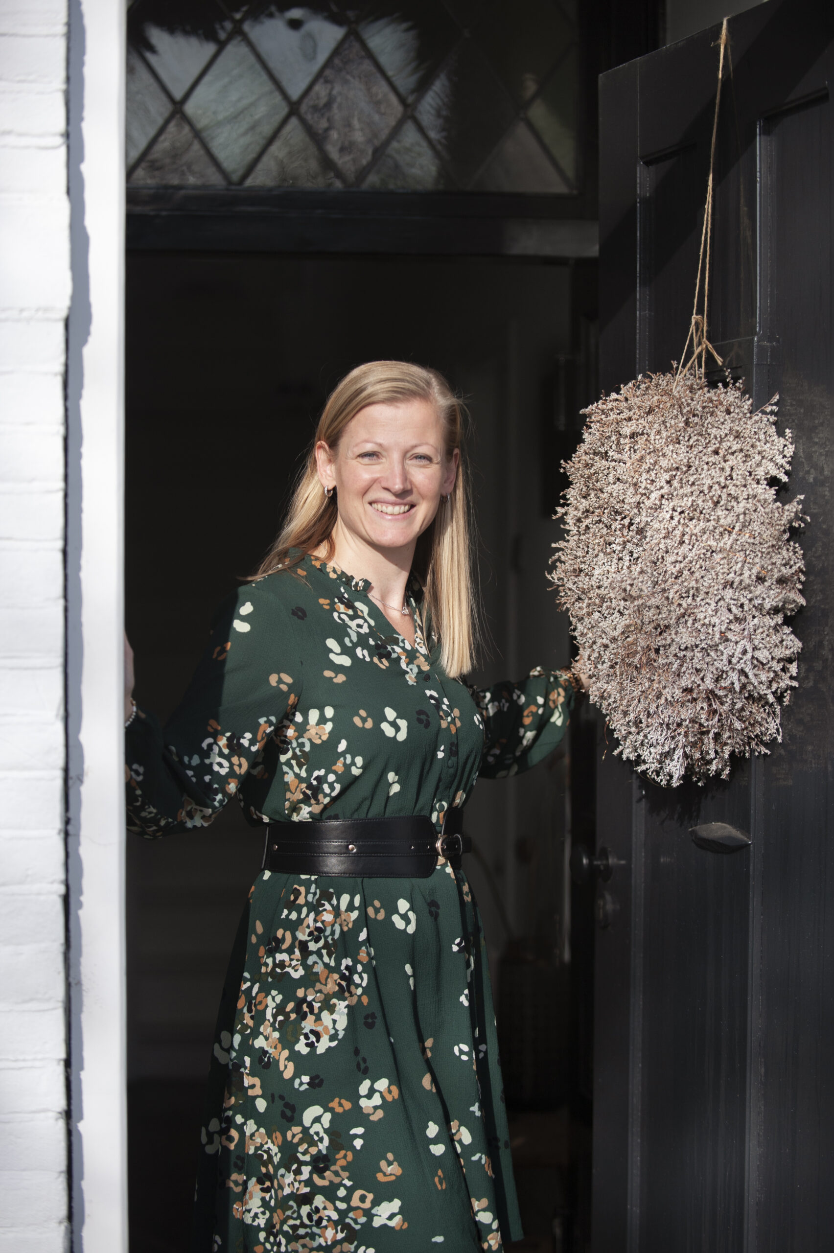 In de deuropening welkom heten bij de lezing over hoogbegaafdheid en opvoeden.